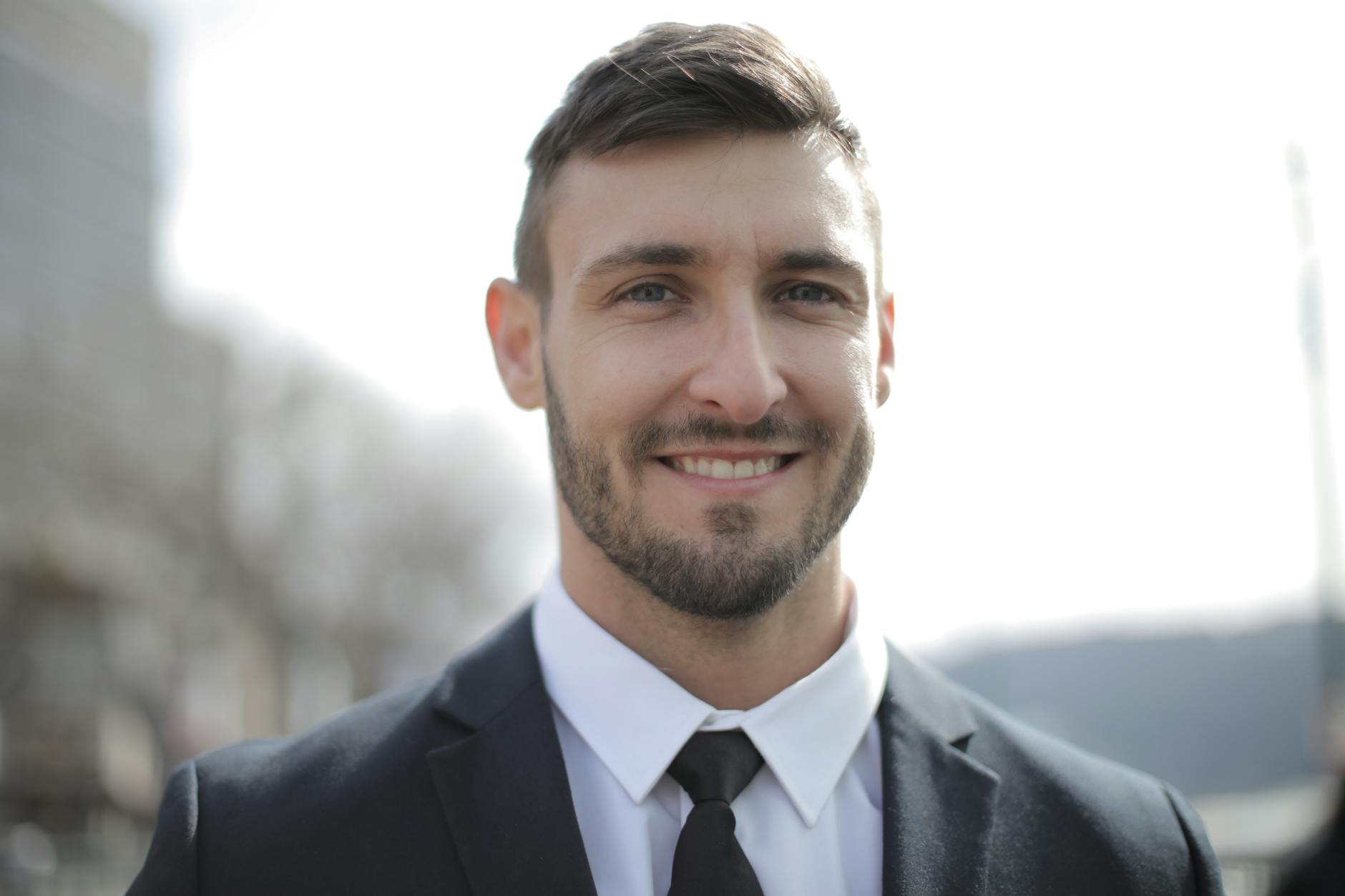 man in black suit jacket smiling